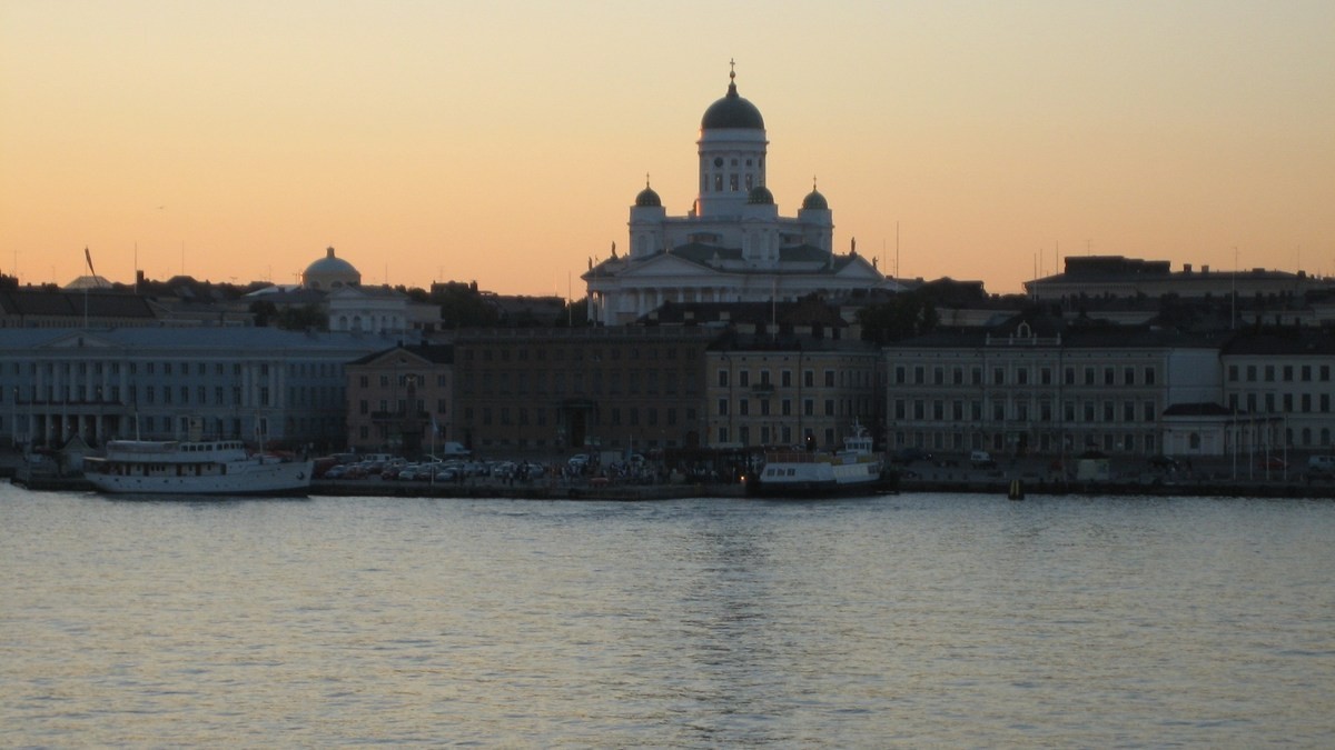 Helsinki’s waterfront and cathedral viewed from the sea at dusk.
