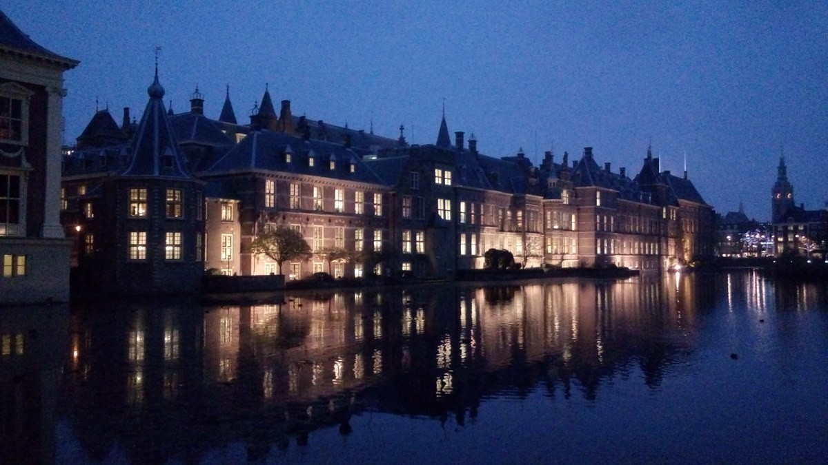Binnenhof buildings reflected in the Hofvijver in The Hague at dusk.
